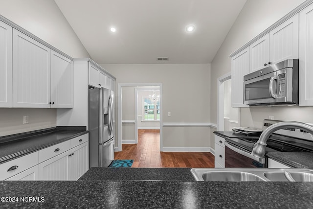 427 Candlewood Dr, Jacksonville, NC 28540 - kitchen featuring dark wood-type flooring, sink, vaulted ceiling, appliances with stainless steel finishes, and white cabinets