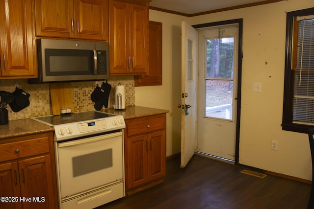 kitchen featuring tasteful backsplash, a healthy amount of sunlight, dark hardwood / wood-style floors, and white range with electric stovetop