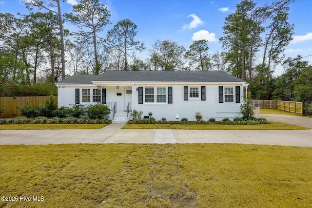 single story home featuring a front lawn, fence, and brick siding