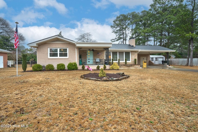 single story home with a carport, a front yard, covered porch, and ceiling fan