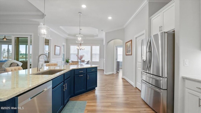 4358 Cobleskill Dr, Leland, NC 28451 - kitchen featuring appliances with stainless steel finishes, a sink, blue cabinets, arched walkways, and white cabinetry
