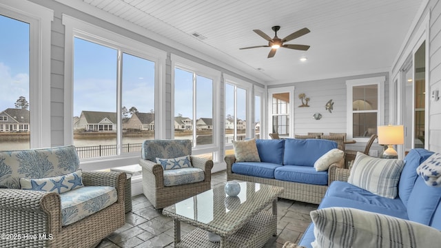 sunroom featuring a ceiling fan, visible vents, and a wealth of natural light