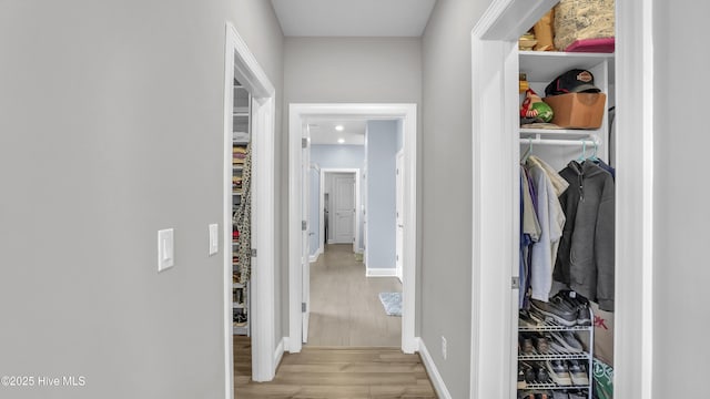 hallway with wood finished floors and baseboards