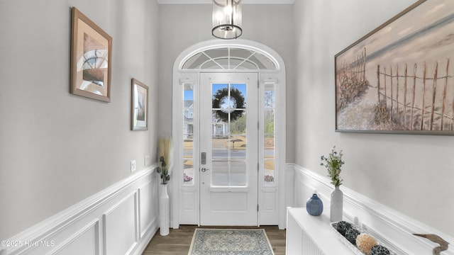 entrance foyer with a wainscoted wall and dark wood-type flooring