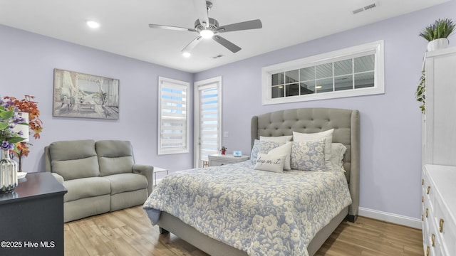 bedroom with visible vents, baseboards, wood finished floors, and a ceiling fan