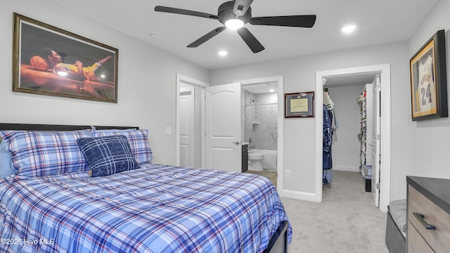 bedroom featuring a walk in closet, baseboards, light colored carpet, ensuite bathroom, and a closet