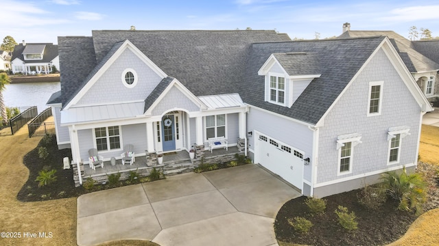 view of front of house with a porch, driveway, roof with shingles, and metal roof