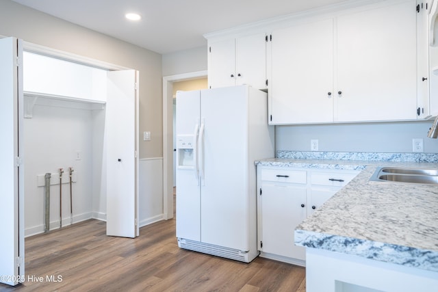 kitchen featuring white cabinetry, white fridge with ice dispenser, sink, and dark hardwood / wood-style floors