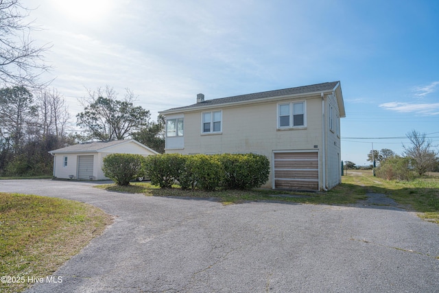 view of side of home featuring an outbuilding and a garage