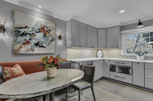 kitchen with tasteful backsplash, gray cabinets, and light countertops