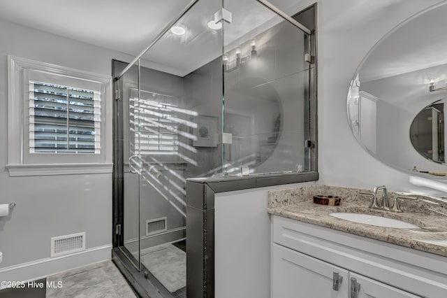 full bath featuring a stall shower, vanity, visible vents, and baseboards