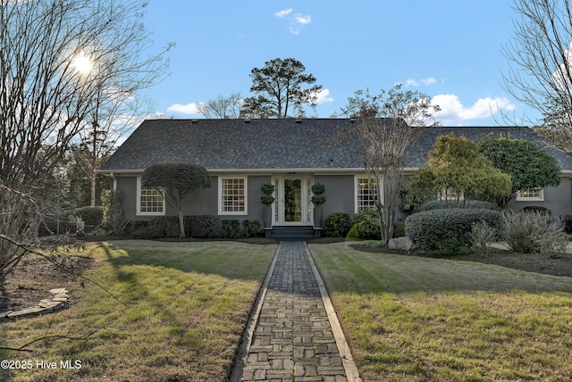 view of front of home featuring a shingled roof, a front lawn, and stucco siding