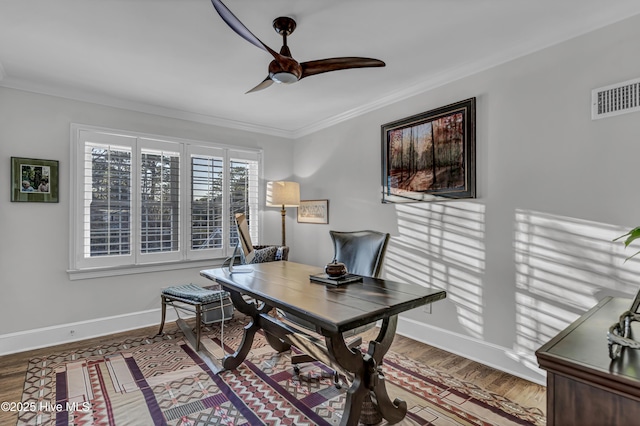 office featuring ceiling fan, wood finished floors, visible vents, baseboards, and crown molding