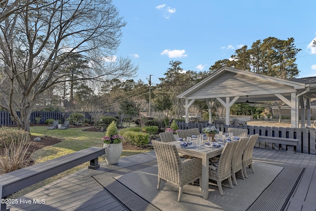 wooden terrace featuring a yard, outdoor dining space, a gazebo, and fence