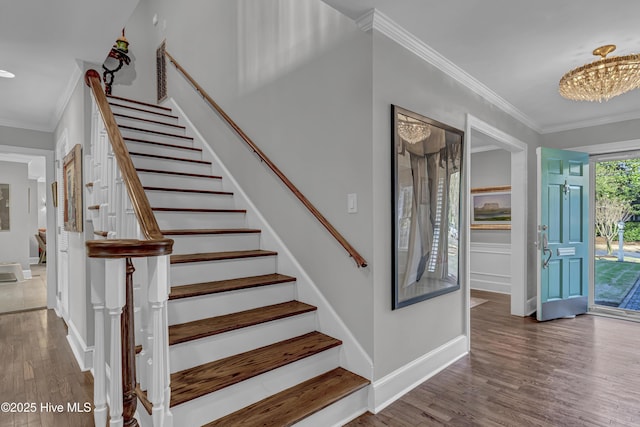 stairway featuring crown molding, baseboards, and wood finished floors