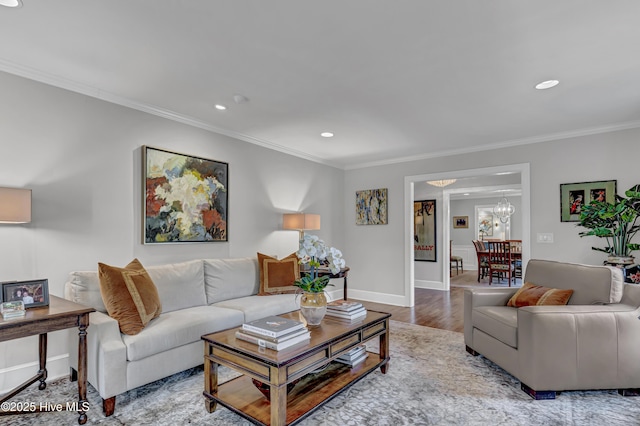 living room featuring recessed lighting, crown molding, wood finished floors, baseboards, and an inviting chandelier