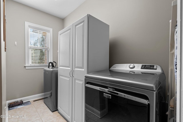 laundry area with washer / dryer, light tile patterned floors, and baseboards