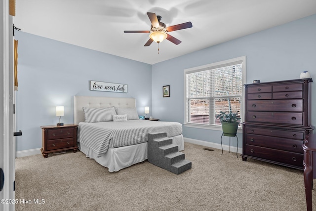 bedroom with a ceiling fan, light colored carpet, visible vents, and baseboards