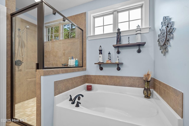 bathroom featuring a garden tub and a shower stall