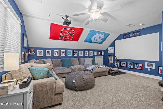 home theater room with lofted ceiling, carpet flooring, visible vents, and a ceiling fan