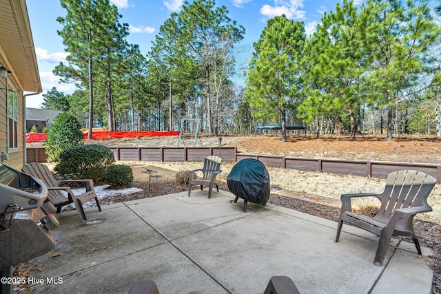 view of patio with a trampoline and a grill