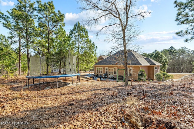 rear view of house featuring a trampoline