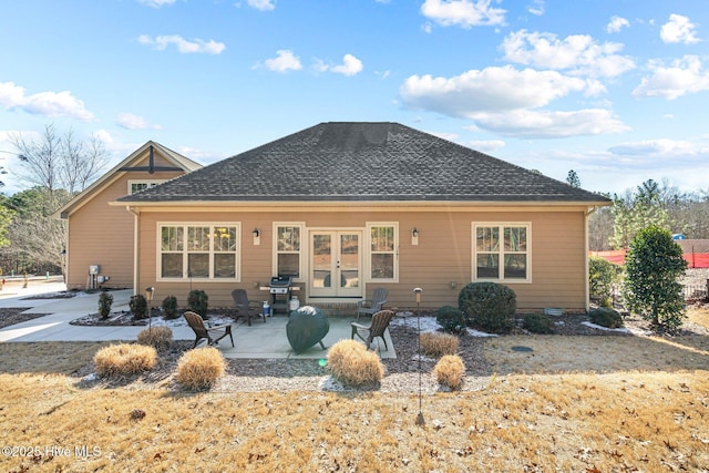 back of house featuring french doors, roof with shingles, and a patio