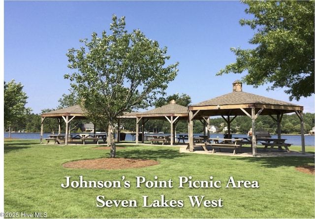 view of property's community with a water view, a lawn, and a gazebo