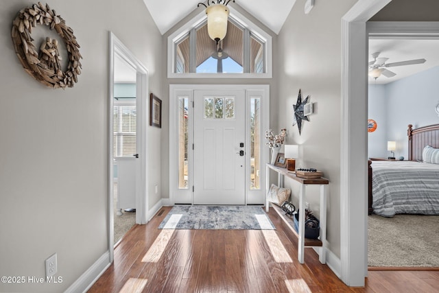 entrance foyer featuring vaulted ceiling, wood finished floors, a ceiling fan, and baseboards