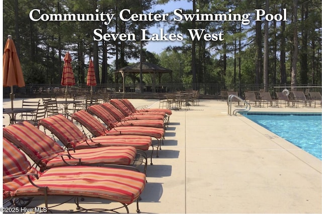 community pool with a gazebo, a patio, and fence