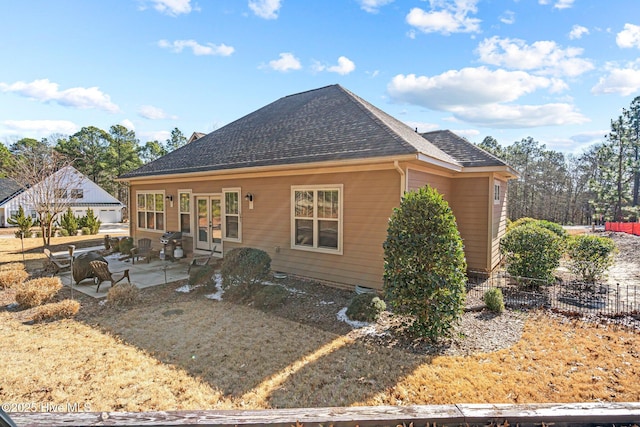 rear view of property with a patio area and a shingled roof