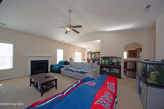 living room featuring vaulted ceiling, light colored carpet, and a healthy amount of sunlight