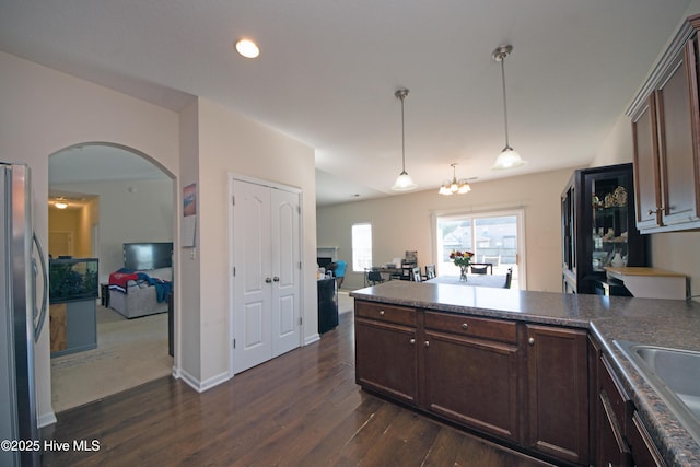 kitchen featuring pendant lighting, sink, stainless steel fridge, dark wood-type flooring, and dark brown cabinets