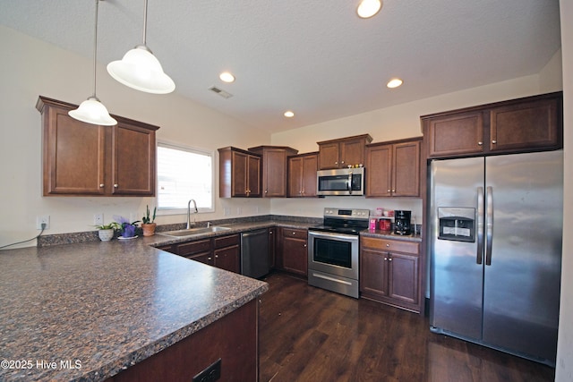 kitchen featuring pendant lighting, sink, dark wood-type flooring, dark brown cabinets, and stainless steel appliances