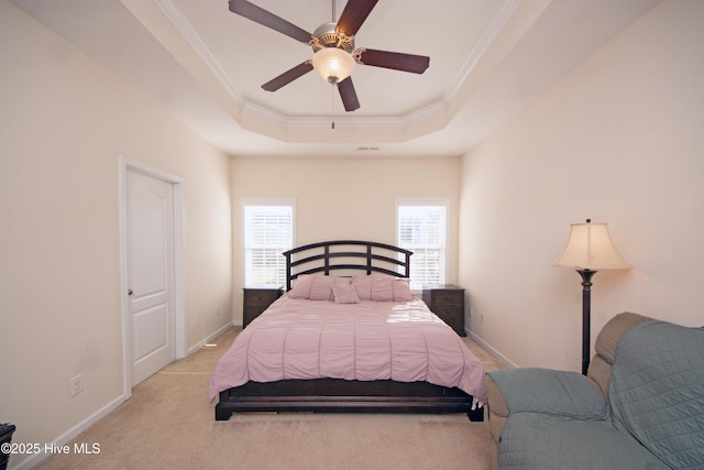 bedroom featuring ceiling fan, light colored carpet, ornamental molding, and a raised ceiling