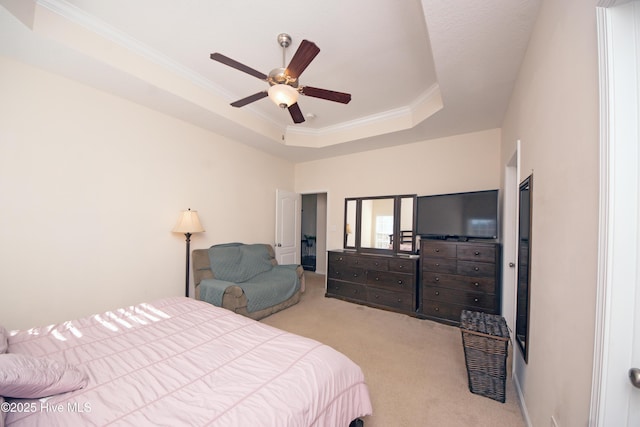 carpeted bedroom featuring crown molding, ceiling fan, and a tray ceiling