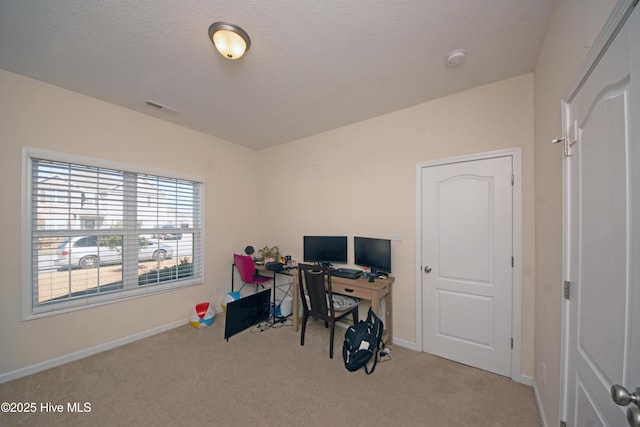 carpeted office space featuring a textured ceiling