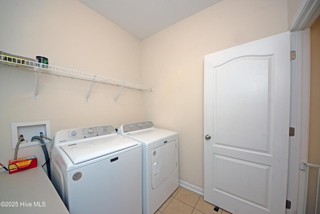 laundry area with light tile patterned floors and washer and clothes dryer