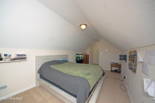 bedroom featuring lofted ceiling, light colored carpet, and a textured ceiling