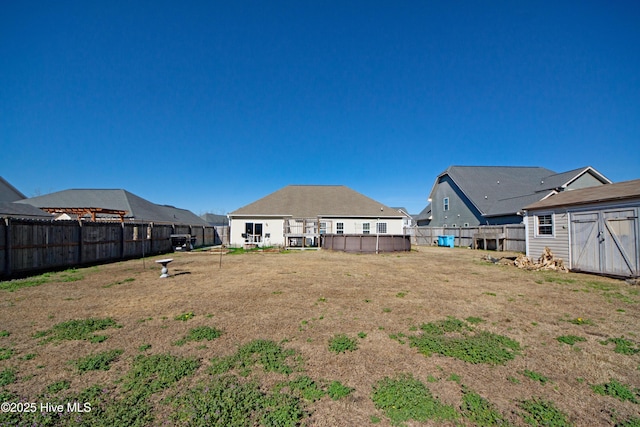 view of yard with a pool and a storage unit