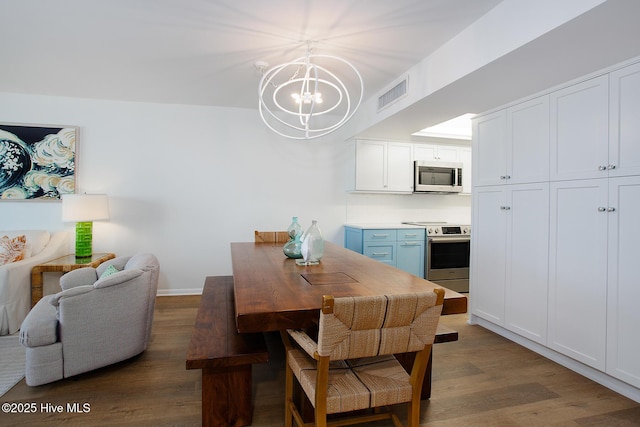 dining room featuring visible vents, a notable chandelier, baseboards, and wood finished floors