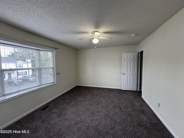 carpeted spare room with ceiling fan and a textured ceiling