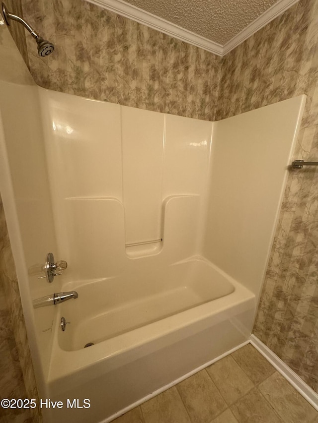 bathroom with tile patterned flooring, ornamental molding, a textured ceiling, and bathtub / shower combination