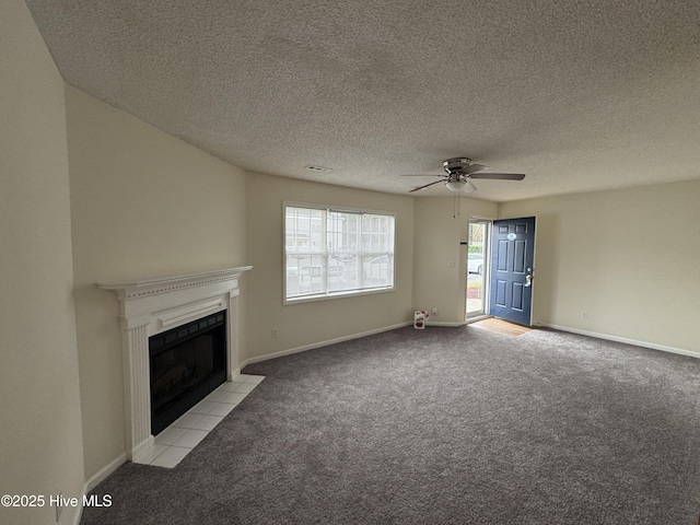 unfurnished living room with ceiling fan, light colored carpet, a textured ceiling, and a fireplace