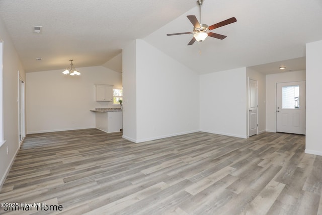 unfurnished living room with lofted ceiling, light wood-style flooring, and baseboards