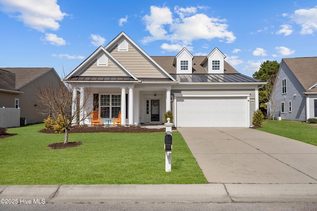 view of front of home with a garage, a standing seam roof, driveway, and a front lawn