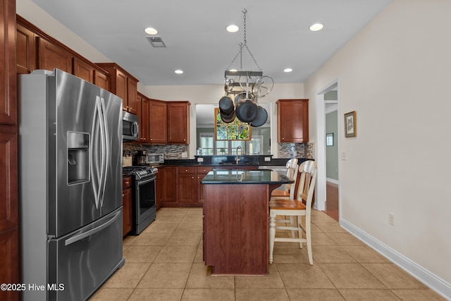 kitchen with stainless steel appliances, dark countertops, visible vents, and light tile patterned floors