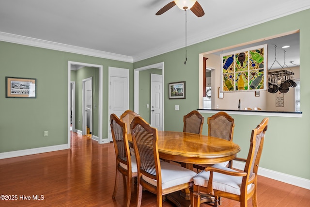 dining space with ornamental molding, baseboards, and wood finished floors