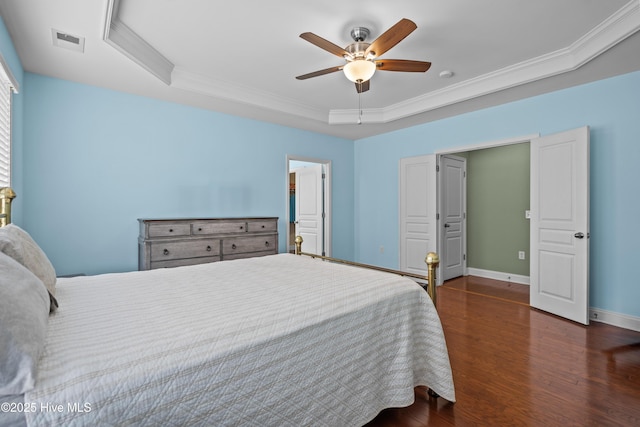 bedroom featuring a raised ceiling, visible vents, ornamental molding, wood finished floors, and baseboards