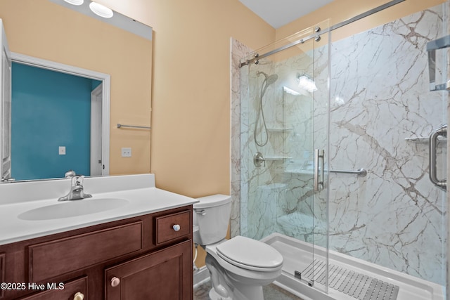 bathroom with vanity, a marble finish shower, and toilet